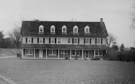 A black and white image of an old farm house.