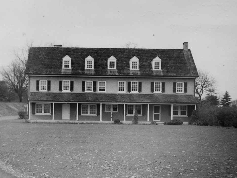 A black and white image of an old farm house.
