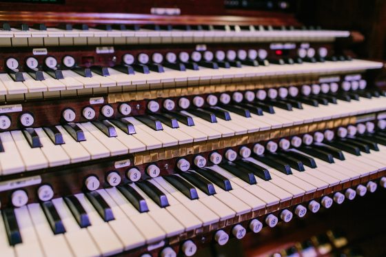 A close up of an organ console and keys.