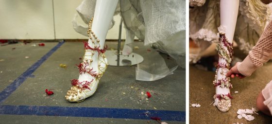 a white foot of a mannequin in beads and floral material going up the leg