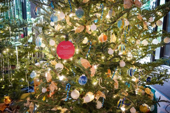 A Christmas tree decorated with ornaments made by young children in a blue and gold palatte.