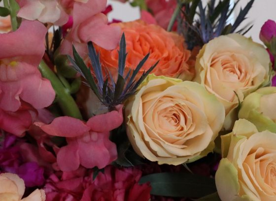 bouquet of flowers containing white roses and pink and oranges blooms