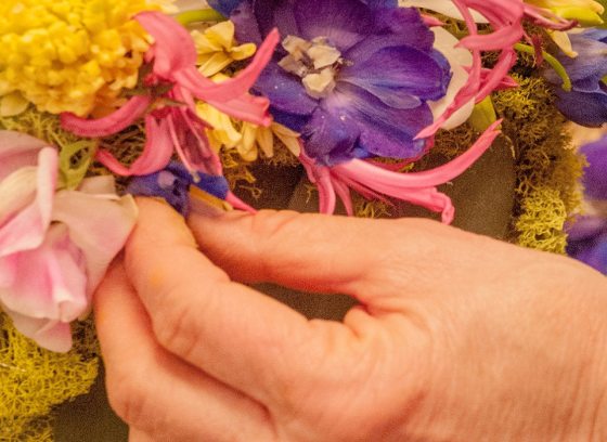 a hand of a person arranging flowers