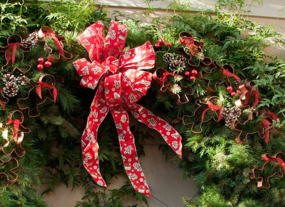 top half of a green wreath with a red bow