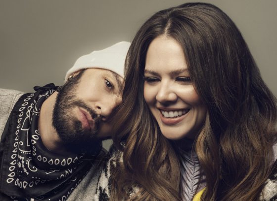 Two adults in front a wall