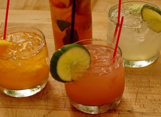 four cocktails in glasses on a wooden table