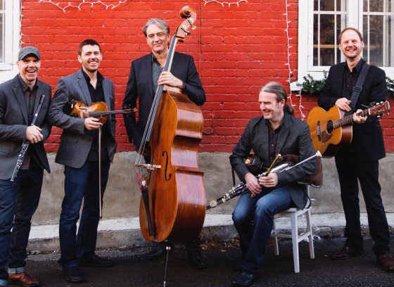 Musicians standing in front of a wall