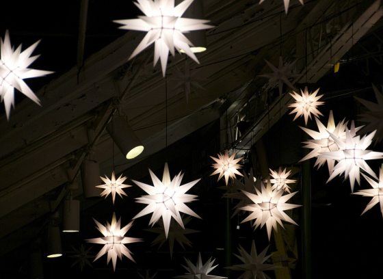 A night sky with white lit star ornaments.