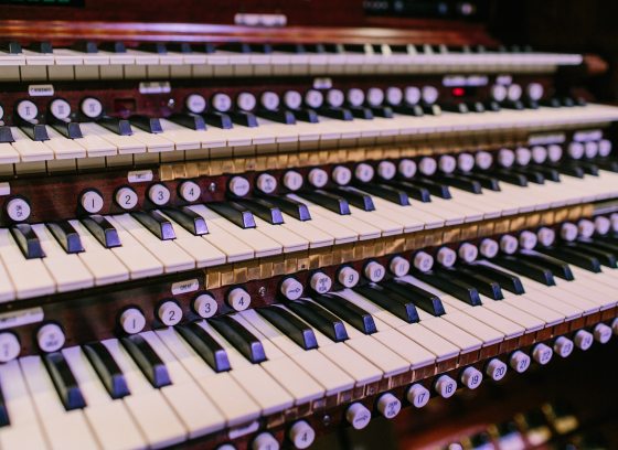 A close up image of an organ console and the keys.