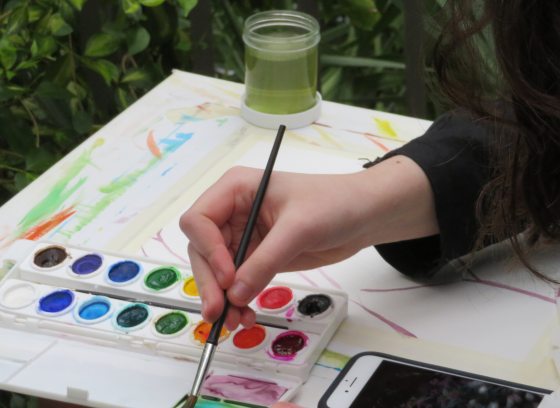 Person mixes watercolors in a tray