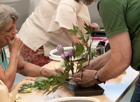 People around a table creating a floral arrangement.