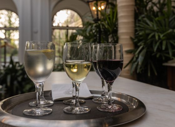 Four glasses of wine on a silver tray.