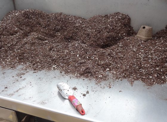 A bunch of soil in heaps on a metal table.