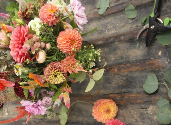 A floral arrangement being crafted on a wood table