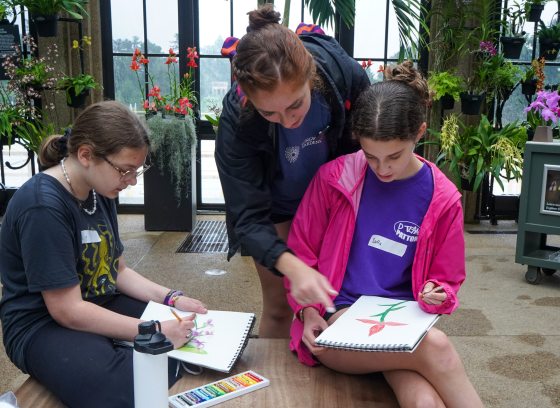 Instructor and two youth workshop students illustrating orchids 
