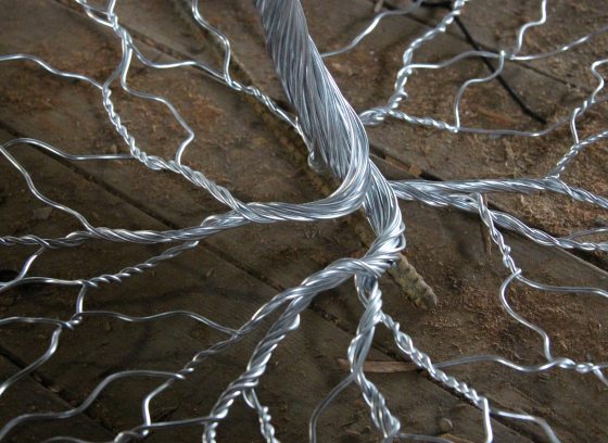 Tree trunk and roots constructed in twisted silver metal