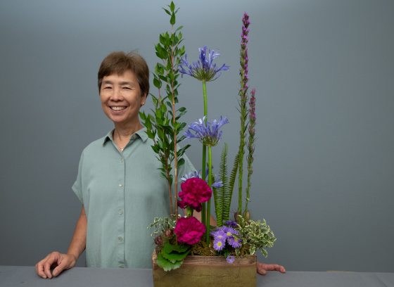Cres Motzi standing next to a linear floral design centerpiece