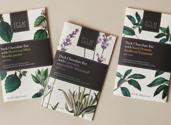 Three bars of Eclat chocolate, featuring floral motif, against a tan background.