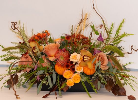 A autumn theme floral arrangement in oranges and yellows.