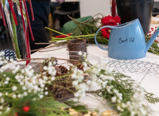 Holiday floral arrangement supplies laid out on a table.