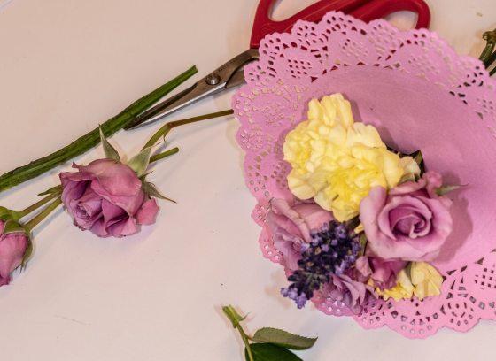 A small floral bouquet encased by a pink doily.