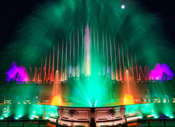 fountains in green, fuchsia, and fiery yellow-orange against a black night sky