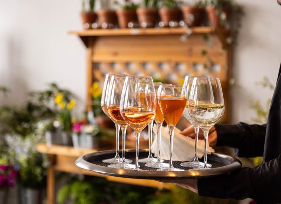A tray of wine glasses, being carried on a tray.