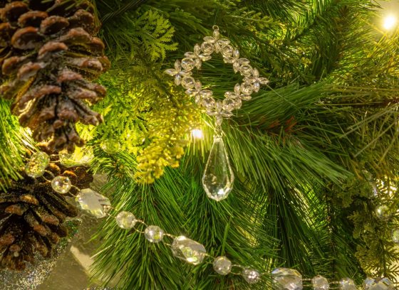 A close up of evergreen garland, decorated with pinecones and crystals.