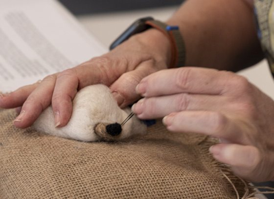 A person working on a needle felt project.