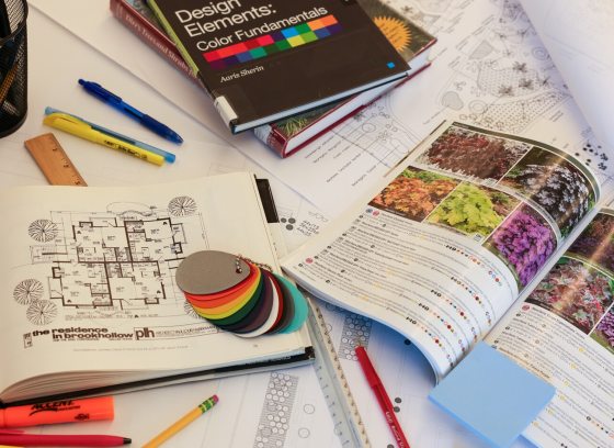 An assortment of landscape design books and materials open on a table.