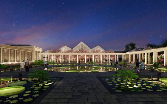 Pools of water plants surrounded on 3 sides by large white buildings marked by columns and peaked roofs