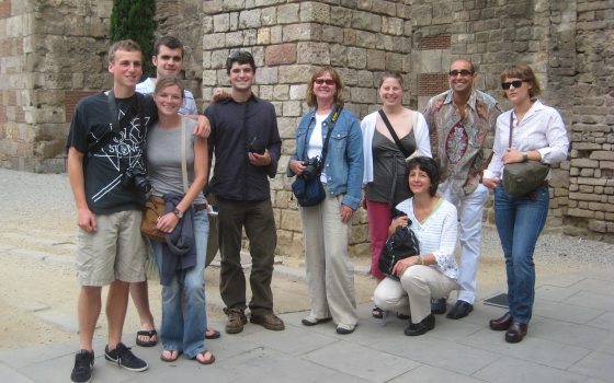 a group of 9 adults pose for a picture on the streets of Spain