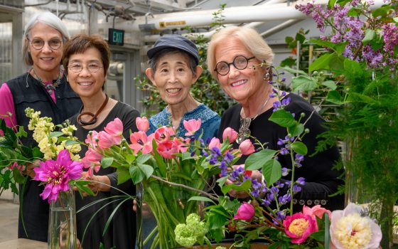 group of four people standing in front of floral arrangements