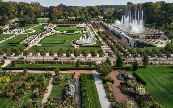 Aerial view of a large fountain garden to the upper right, a topiary garden at the top, and a lined flower bed garden at the bottom