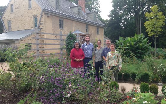 a group of five people standing in a small garden