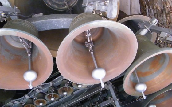 shot from below looking into interior of 3 carillon bells with clappers