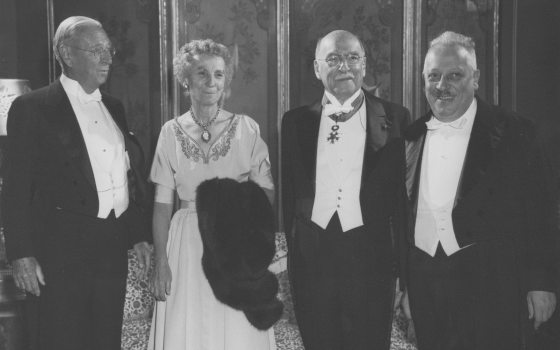 a black and white photo of a group of people in evening wear 