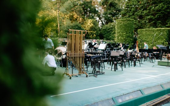 adults set up instruments in an outdoor venue