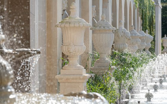 closeup of fountain facade with urns, spouting masks, and small fountains set in basin
