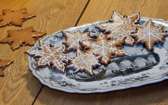 star shaped cookies decorated with white icing on a blue and white plate