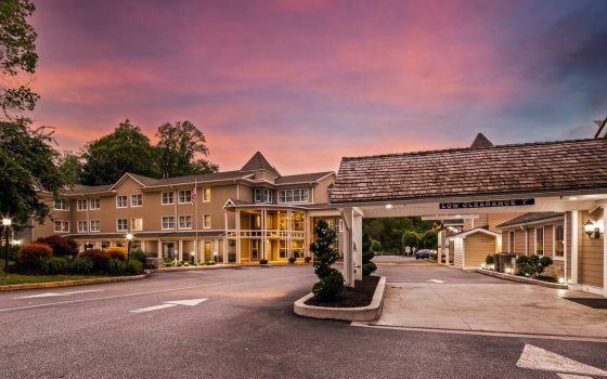 sunset image of a hotel reception and parking lot
