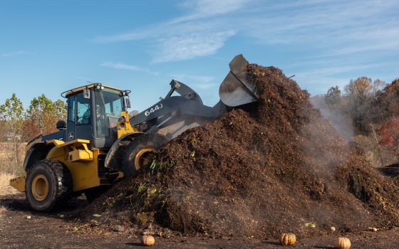 A bulldozer moving a large pile of dirt. 