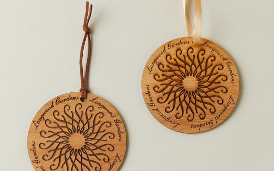 Two wood ornaments featuring the Longwood rosette.