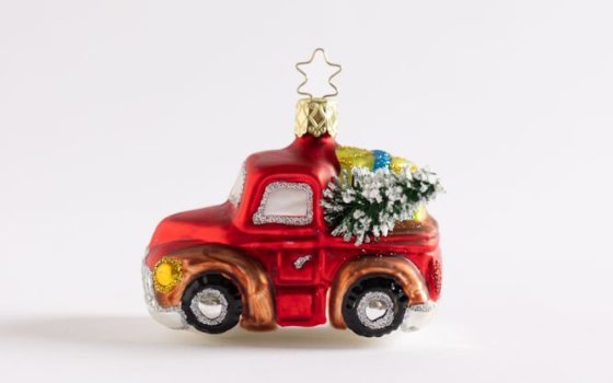 An ornament of a red truck with christmas tree in the bed.