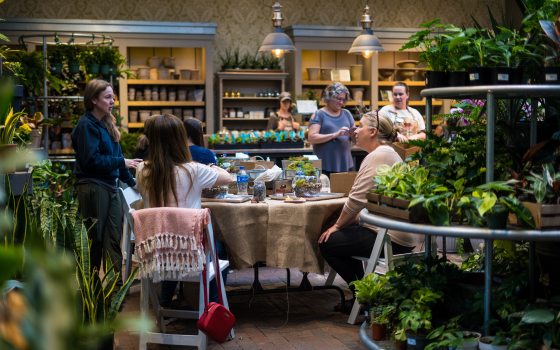People seated at tables creating terrariums inside the Garden Shop at Longwood Gardens.