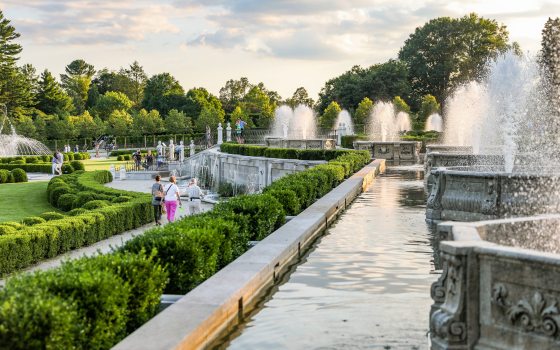 People of all ages stroll through a fountain garden.