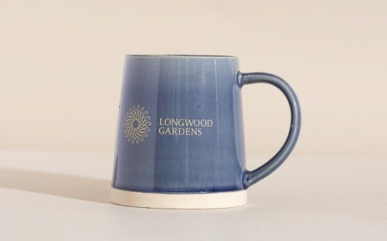 A blue ceramic mug that reads Longwood Gardens.