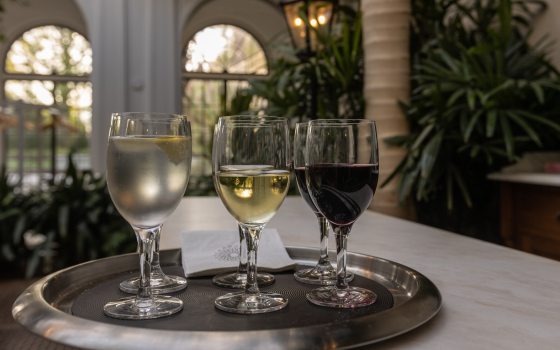 Four glasses of wine on a silver tray.