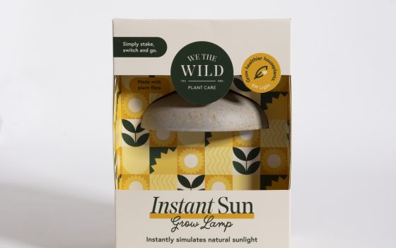 A white, yellow box with black writing, containing a small grow light.
