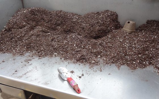 A bunch of soil in heaps on a metal table.